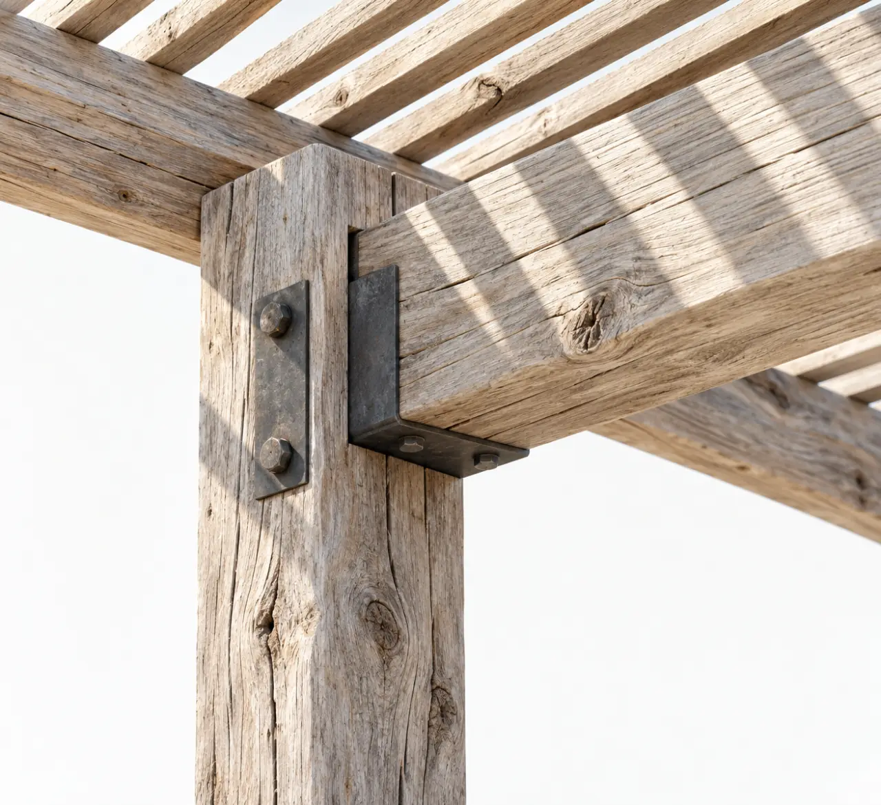 Détail d'une pergola bois flotté montrant les assemblages, les fixations et la couverture ajourée